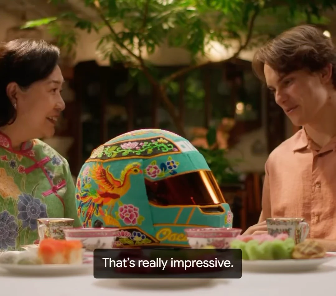 Angeline Kong and Oscar Piastri sit on either side of his turquoise Peranakan beaded helmet.