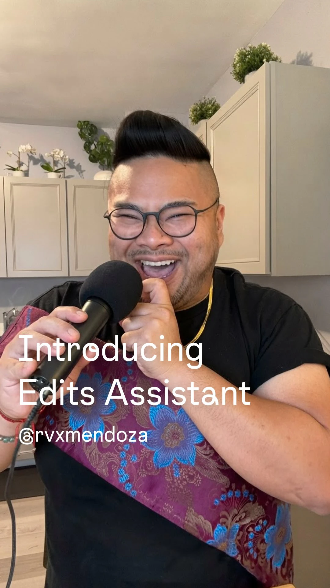 RV Mendoza laughs into a microphone beneath the words Introducing Edits Assistant.