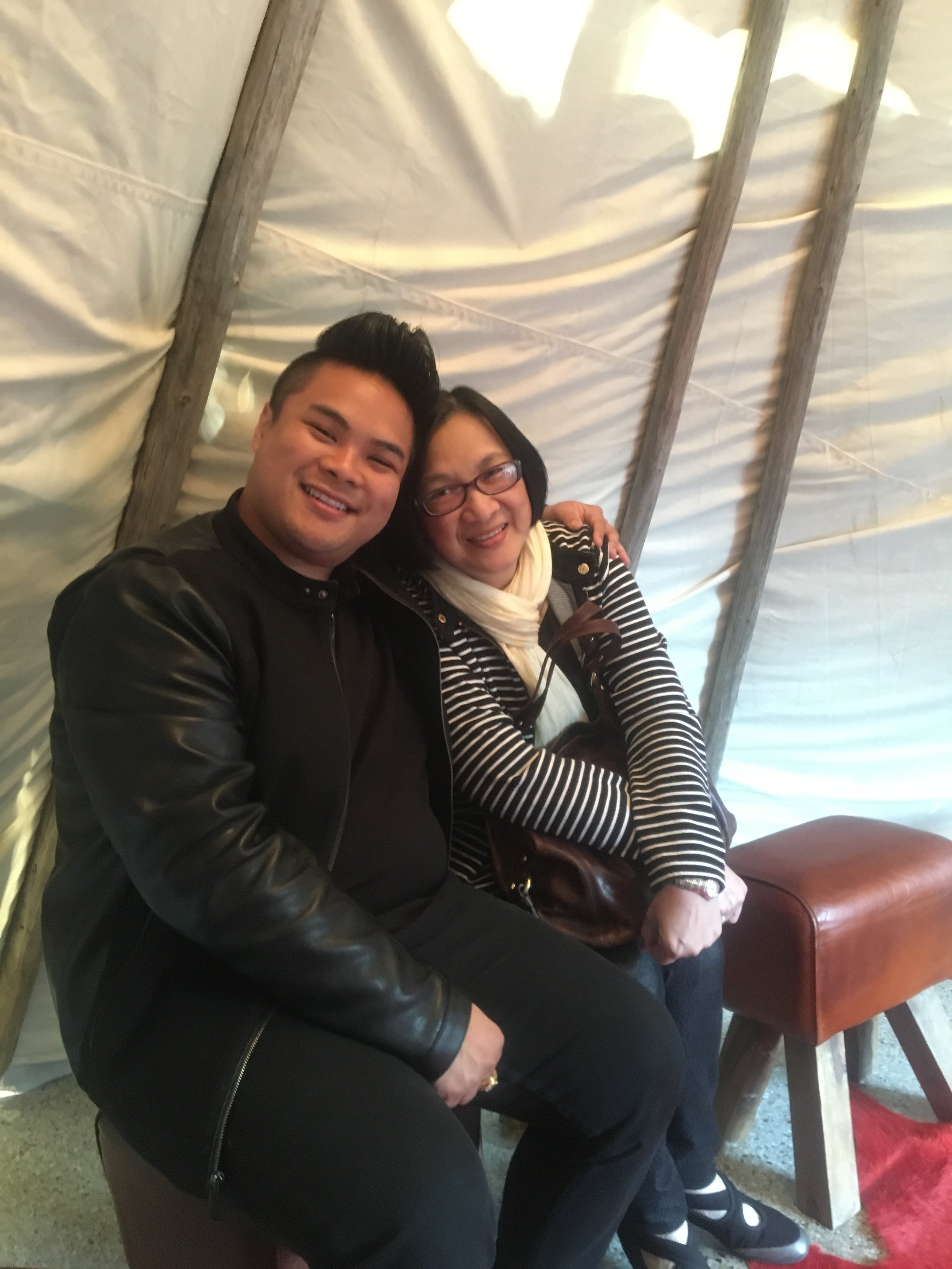 RV Mendoza and his mother sit together with their arms around each other.