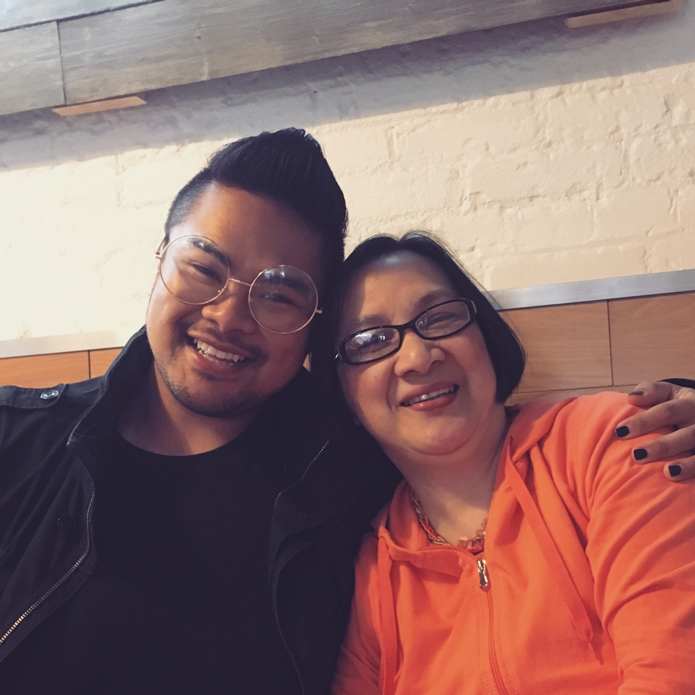 RV Mendoza and his mother smile together at a restaurant.